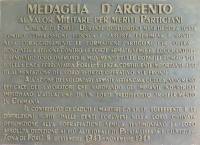 La targa che ricorda la medaglia d'argento per meriti partigiani assegnata al Comune di Forlì. Il bronzo è affisso nello scalone monumentale della casa comunale in piazza Saffi.